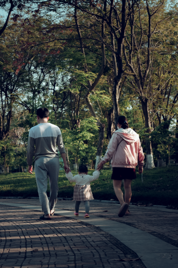 man and woman walking with their child