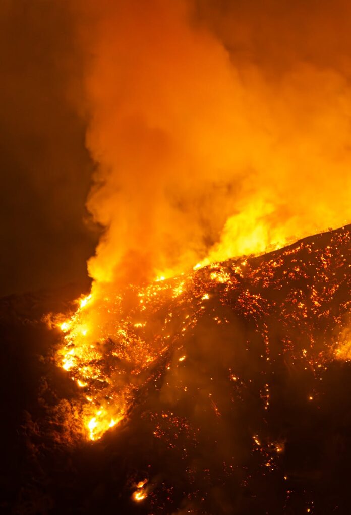 intense wildfire blaze illuminating night in california