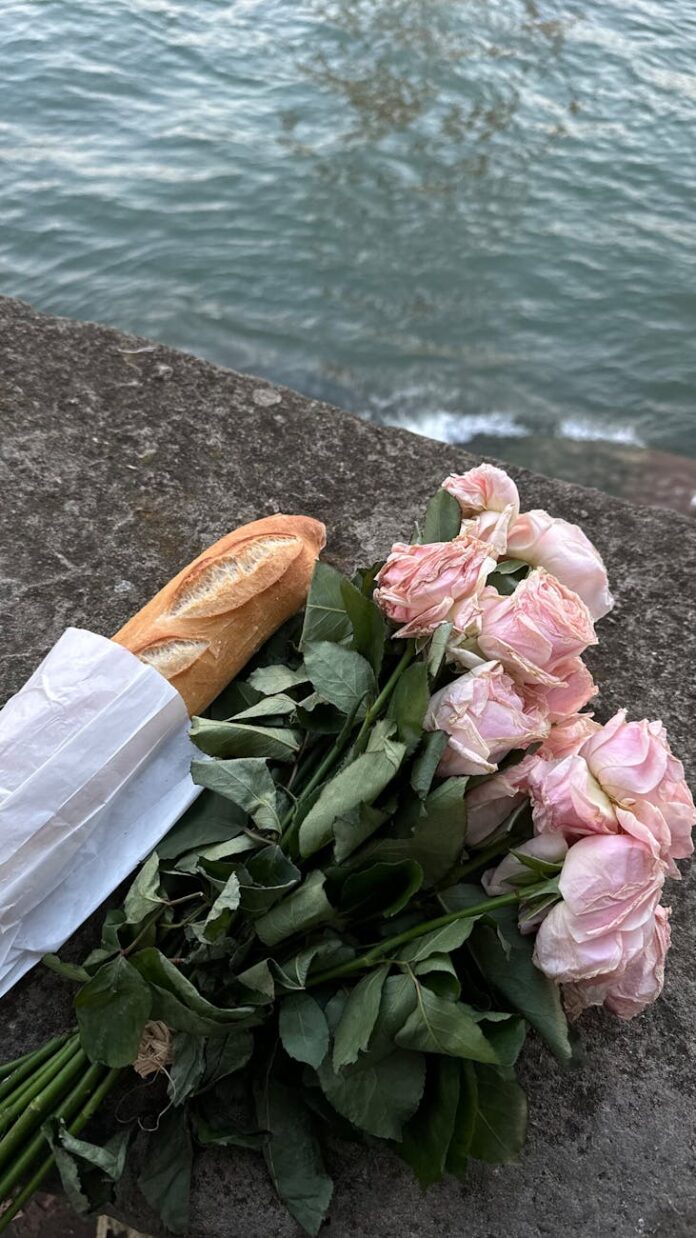 bouquet of pink roses with baguette by water
